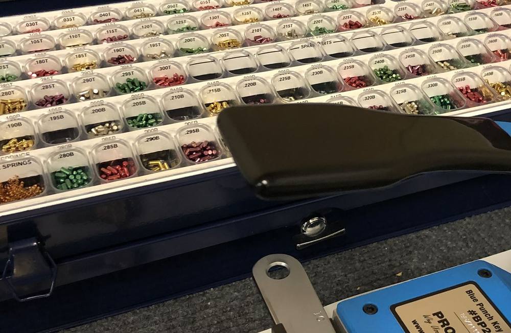 A LAB pinning kit with colour-coded pins beside a Pro-Lok key machine in the van.